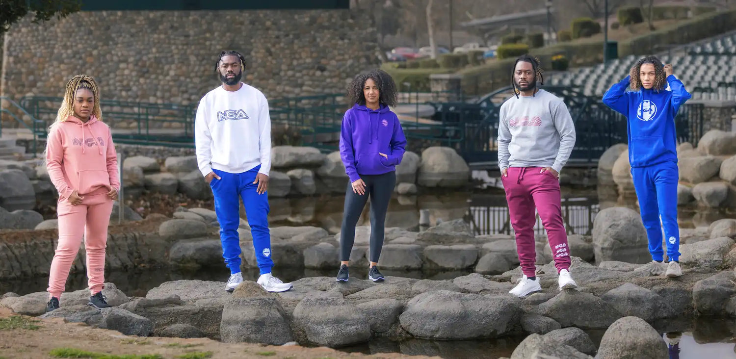 Five people wearing colorful tracksuits.