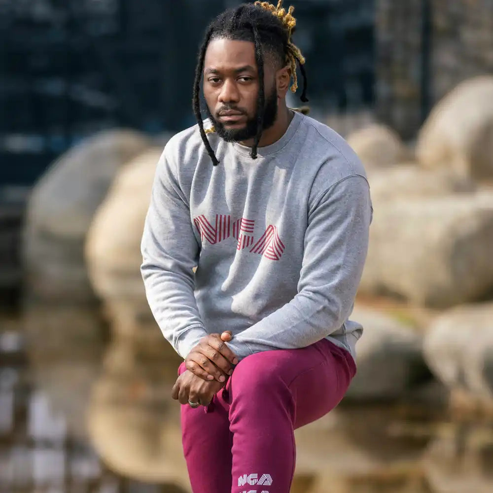 Man in gray sweatshirt and maroon pants.