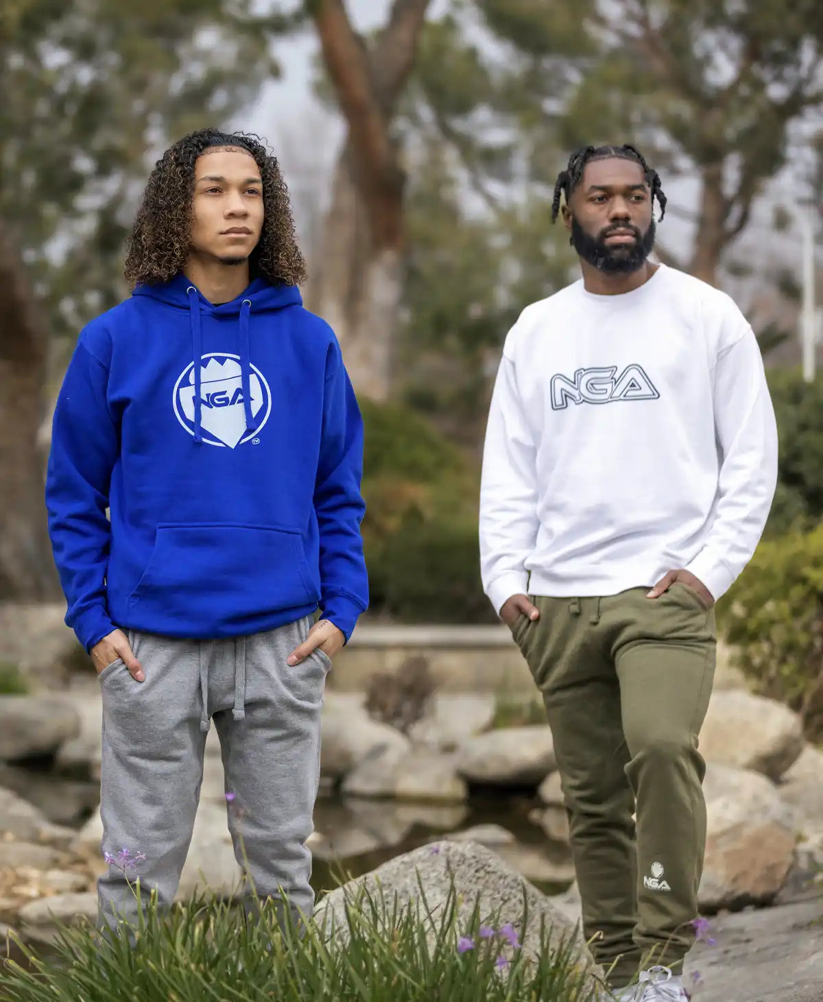 Two men wearing branded sweatshirts and sweatpants.